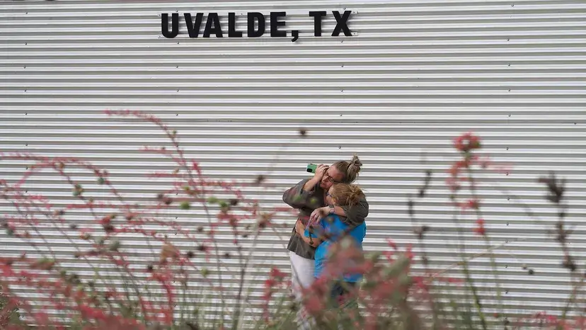 Uma mulher chora e abraça uma jovem do lado de fora do Centro Cívico Willie de Leon em Uvalde
