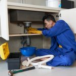asian plumber blue overalls clearing blockage drain 1098 17773 1