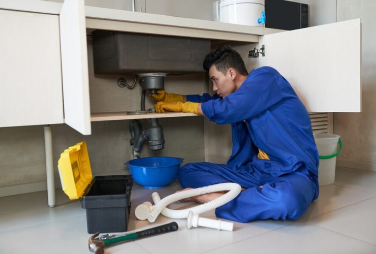 asian plumber blue overalls clearing blockage drain 1098 17773 1