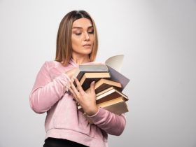 Por que a Barra da Tijuca se tornou o point dos concurseiros no Rio? Descubra! 7 girl pink sweatshirt holding stock books opening one top reading it 114579 27065