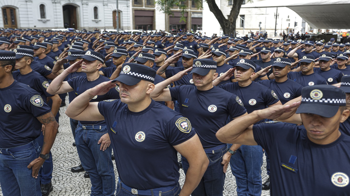 Novo concurso GCM SP: Oportunidades para 2025 1 Policiais em uniforme fazem continência durante cerimônia pública em área urbana